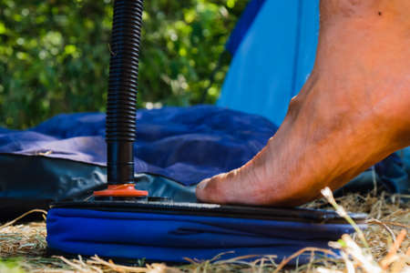Bare dirty male feet resting on a plastic inflatable mattress outdoorsの写真素材