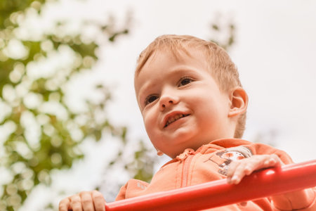 Funny child on playground play fun in summer park