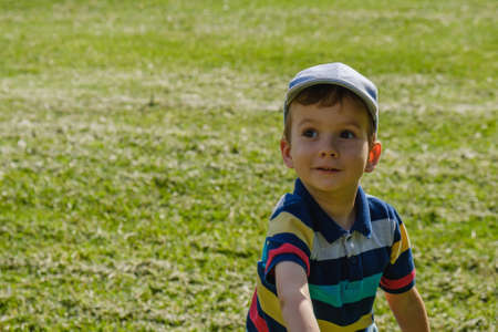 Boy playing with a toy plane at park on a sunny summer dayの写真素材