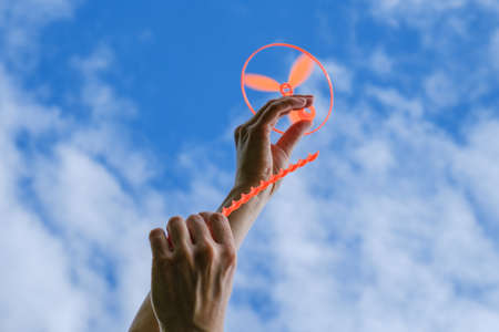 Toy propeller in hand - play with kids on outdoor in summer, launch toy helicopterの写真素材