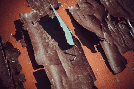 Texture of a peeling red paint on an old wooden surface.の写真素材