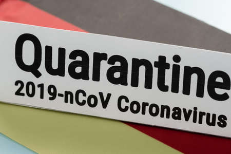 Pandemic sign warning of quarantine due to Covid-19 or corona virus in the Germany using a German flag background protection.の写真素材