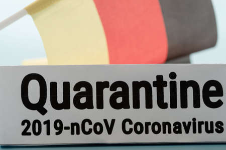 Pandemic sign warning of quarantine due to Covid-19 or corona virus in the Germany using a German flag background epidemic.の写真素材