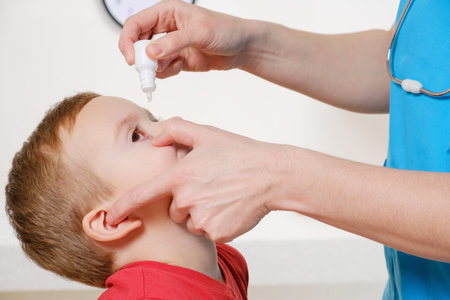 Closeup of doctor pouring eye drops in eye her patient. Studio shot