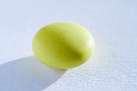 Green Pill tablet medicine lying isolated on white background extreme close-up macro.の写真素材