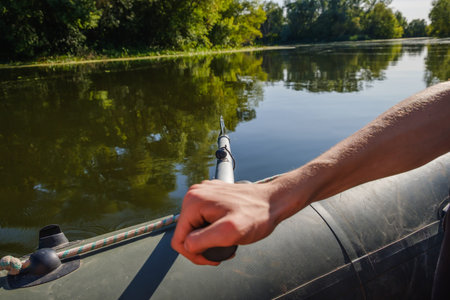 rubber boat, hunter or fisherman man's hand holding paddle