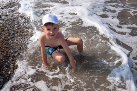Happy child play in ocean or sea beach, water. nature playingの写真素材