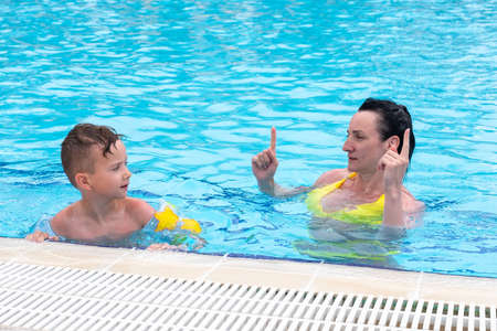 Mother son pool fun family game water. summer boyの写真素材