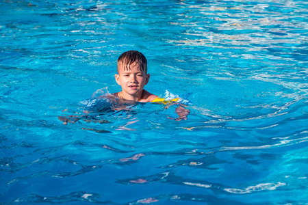 Happy child playing in water pool, fun summer. cute slideの写真素材