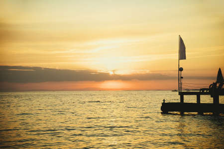 Orange sunset ocean pier and summer beach sky. nature waveの写真素材