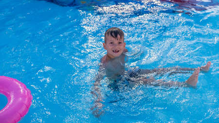 Happy child playing in water pool, fun summer. cute wetの写真素材