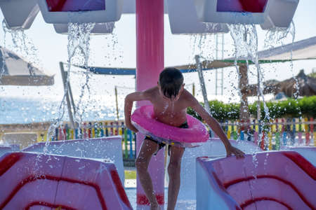 Happy child playing in water pool, fun summer. summertimeの写真素材