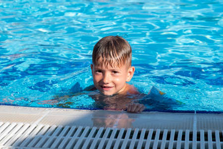 Happy child playing in water pool, fun summer. swim wetの写真素材