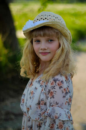 Beautiful girl in a hat, portrait in a summer parkの写真素材