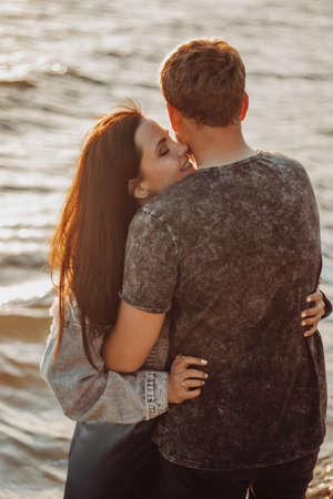 Loving couple cuddles on the seashore in the sunshine.の写真素材