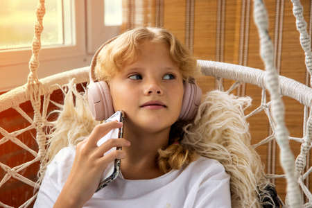 Young girl listening to music with headphones on her mobile phoneの写真素材