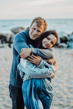Guy hugs a girl on a walk along the beachの写真素材