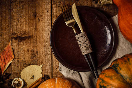 Knife and fork on a plate, autumn table settingの写真素材