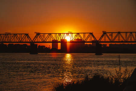 Railway bridge over the river during sunsetの写真素材
