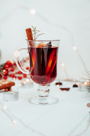 a glass of hot mulled wine with rosemary on a white plate in a New Year's atmosphere. High quality photoの写真素材