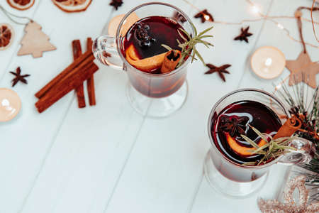 two glasses of hot mulled wine with rosemary on a white plate in a New Year's atmosphere. top view, free space for text. High quality photoの写真素材