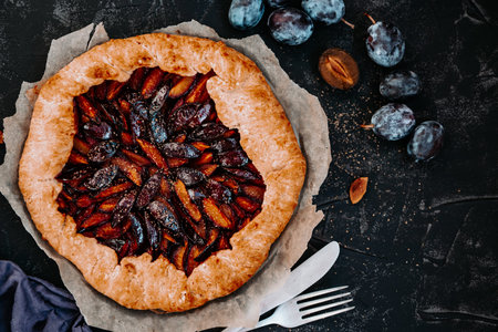 Sweet homemade pie with plums on a black background, top view, copy space. High quality photoの写真素材