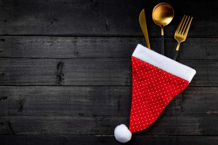 Cutlery and santa claus hat, christmas table setting concept. Free space for text. High quality photoの写真素材