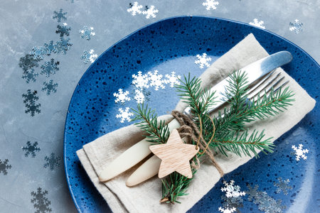 Vintage cutlery on linen napkin and blue plate, beautiful christmas background. High quality photo