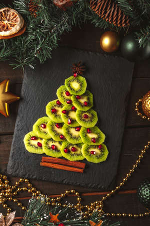 Kiwi and pomegranate christmas tree, new year food concept. Vertical photoの写真素材