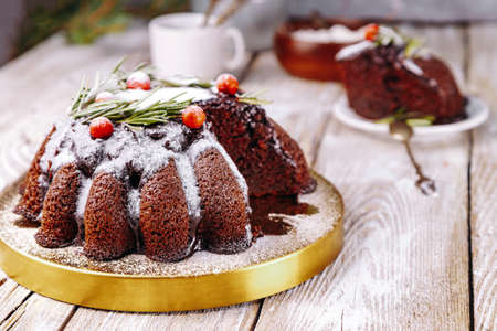 Christmas chocolate cake garnished with berries and rosemary on a white wooden table. High quality photoの写真素材