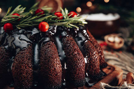 Christmas chocolate cake garnished with berries and rosemary close-up. High quality photoの写真素材