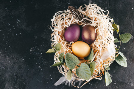 Colored easter eggs on a dark gray background, top view, free space for text