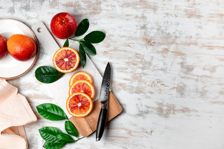 Red bloody oranges cut into slices on a white cutting board top view copyspaceの写真素材