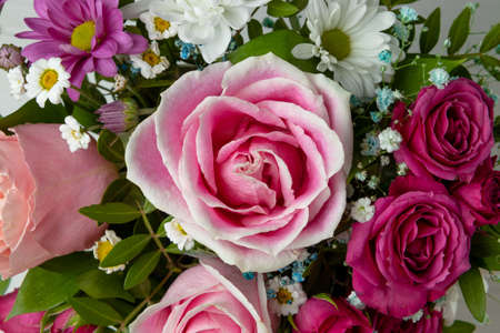 Beautiful summer background with a bouquet of bright flowers close up. Bouquet of pink roses, chrysanthemums and daisies top viewの写真素材