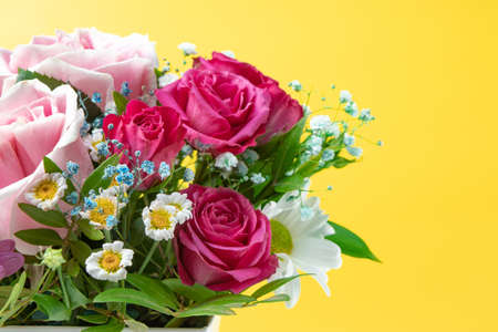 Beautiful summer banner for a website with a bouquet of bright flowers on a modern pink background. Bouquet of pink roses, chrysanthemums and daisies top view, free space for textの写真素材