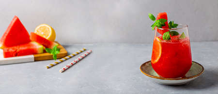 A glass of refreshing summer fresh watermelon with lemon and mint on light gray background, website bannerの写真素材