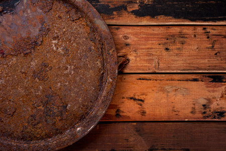 Old rusty round tray on textured old wooden background top view, grunge background with free space for textの写真素材