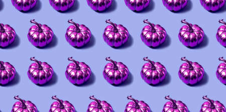 Seamless pattern with golden pink pumpkins on a violet background. Autumn concept in a modern style. High quality photoの写真素材