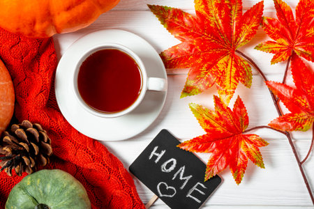 A cup of tea, autumn leaves and pumpkins top view. The concept of a cozy autumn at home. High...