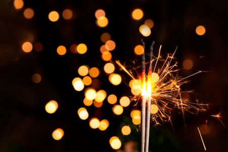 Burning sparkler in a christmas atmosphere at nightの写真素材