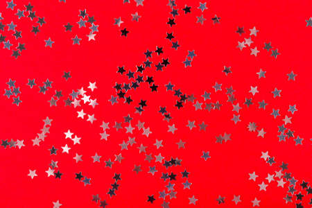 Festive Christmas and New Year background. Silver stars confetti on a red background top viewの写真素材