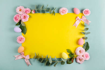 Happy Easter concept with easter eggs and spring flowers. Easter background with copy space. Flat lay.の写真素材