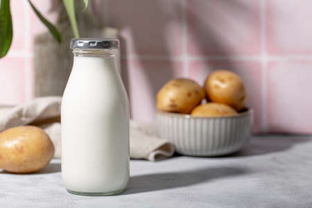 Bottle of potato milk on the table. Plant-Based Potato Milk Alternative, Vegan Milkの写真素材