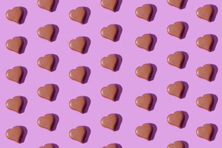 Seamless pattern with heart shaped chocolates on a purple background. Modern Valentine day backgroundの写真素材