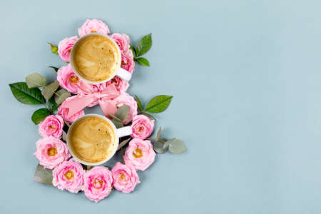International Womens Day. Banner, flyer, beautiful card for March 8. Pink flowers and two cups of coffee in the shape of a figure eight on a blue backgroundの写真素材