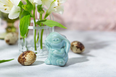 Easter bunny, quail eggs and spring flowers on the pink background. Festive easter card with free text spaceの写真素材