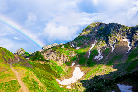 Beautiful rainbow on a green mountain valley, background with natureの写真素材