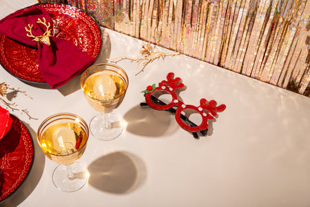 Modern Christmas table setting, red plates with napkins and two glasses of champagne on the festive table copy space for text. High quality photoの写真素材