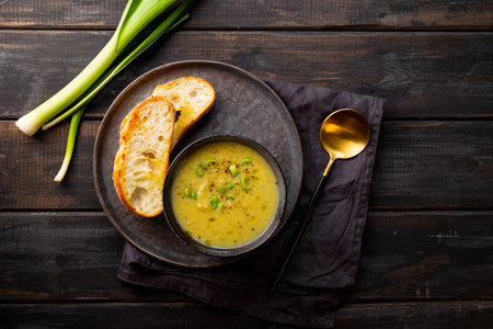 A cup of leek soup with toasted bread on dark wooden background top view. High quality photoの写真素材