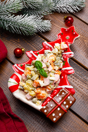 Traditional Russian salad Olivier for the New Year's table on wooden background vertical photo. High quality photoの写真素材